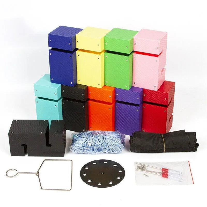 Outdoor team building equipment set with coloured plastic blocks, pull ropes, and a metal hook frame on grass.