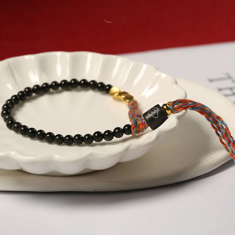 Hand-woven obsidian carrying strap bracelet showing textured surface and 4mm width detail