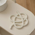 Ceramic heat proof mat with irregular organic shape in solid colour for dining table protection