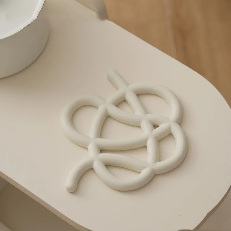 Ceramic heat proof mat with irregular organic shape in solid colour for dining table protection