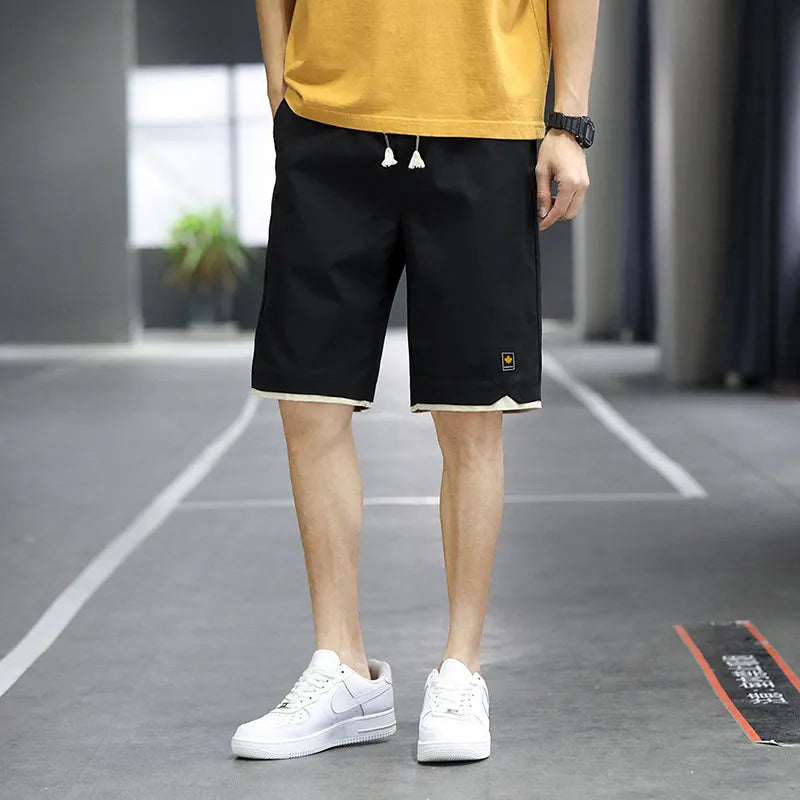 Man wearing loose fit casual polyester shorts in a green colour, showcasing the fifth pants length and Korean style.