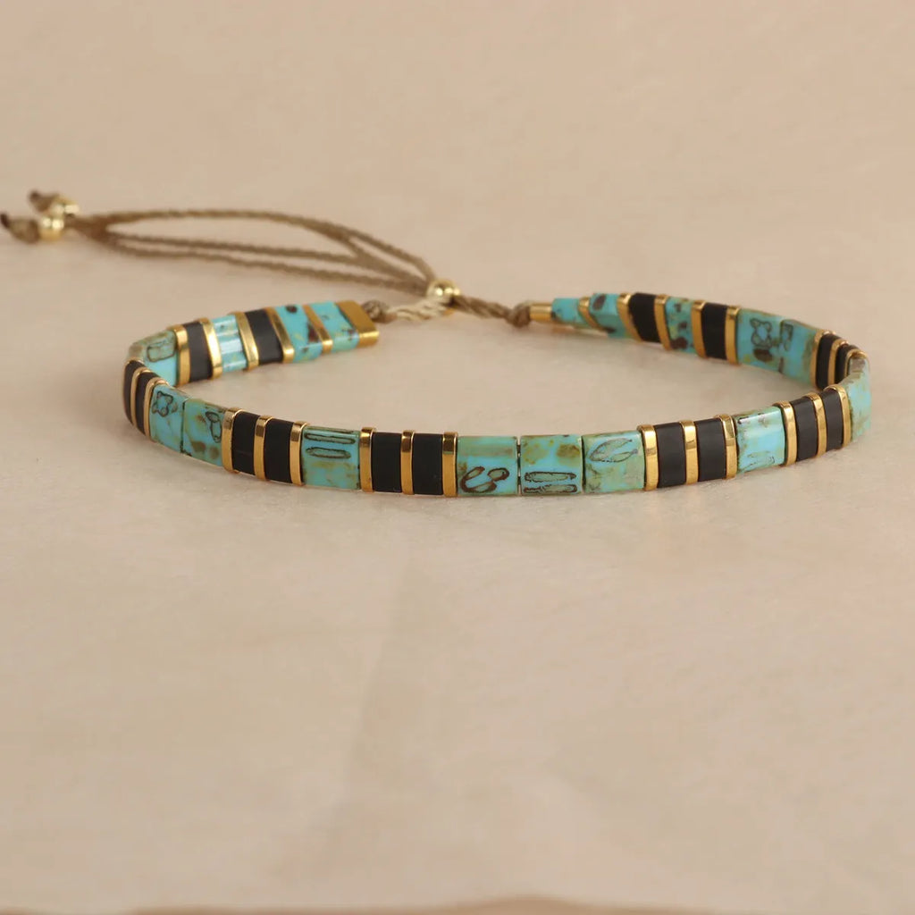 Geometric glass bead pull bracelet in retro green, black, light blue, red, and milky white colours.