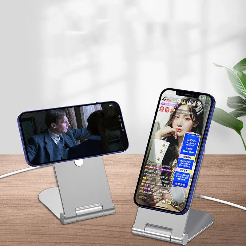 Silver vertical adjustable magnetic phone bracket for iPhone 12 models on a desk.
