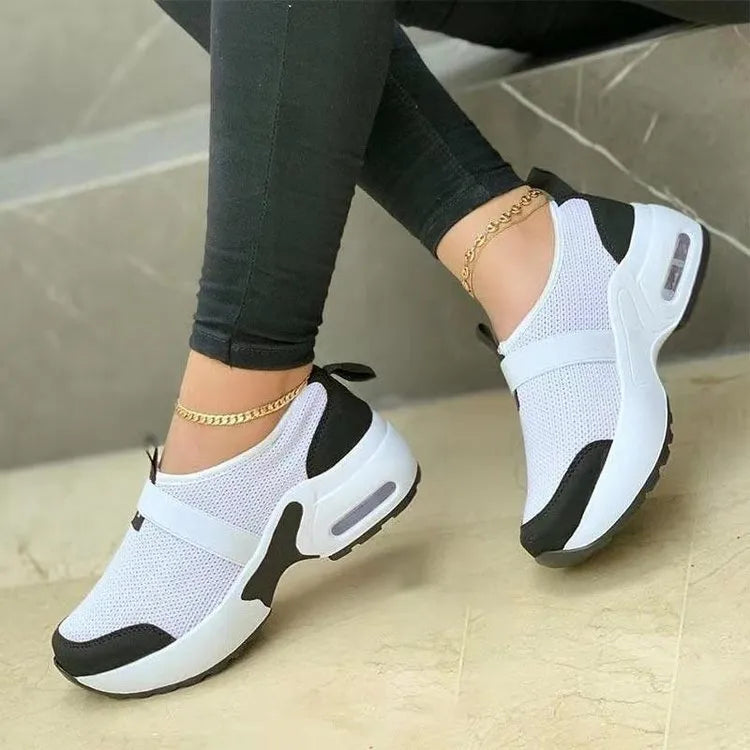 Women's flat mesh sneakers in light grey with white rubber sole and lace-up front.