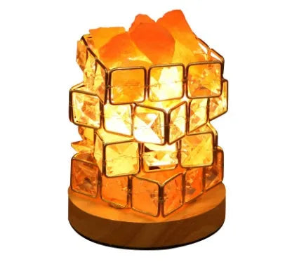 Himalayan crystal salt lamp with dimmer switch on wooden base emitting warm amber glow