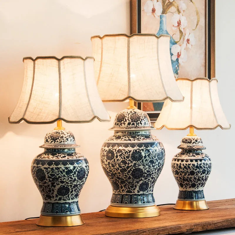 Handmade blue and white porcelain Chinese table lamp with a cloth shade on a wooden surface.