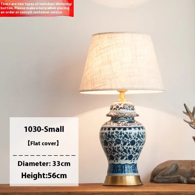 Handmade blue and white porcelain Chinese table lamp with a cloth shade on a wooden surface.