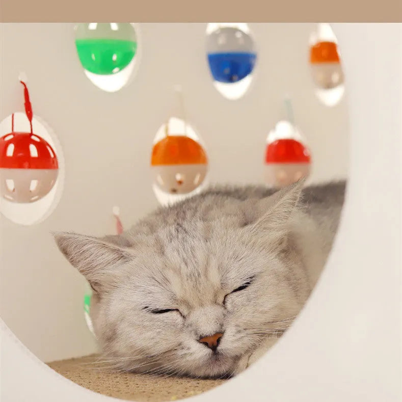 Plastic integrated cat scratch board with attached nest bed and tunnel containing a bell ball toy.