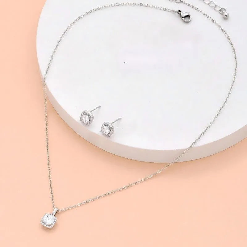 Women's minimalist square cubic zirconia necklace and earring set in gold finish on a light background