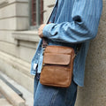 Men's brown leather crossbody shoulder bag with visible sewing detail