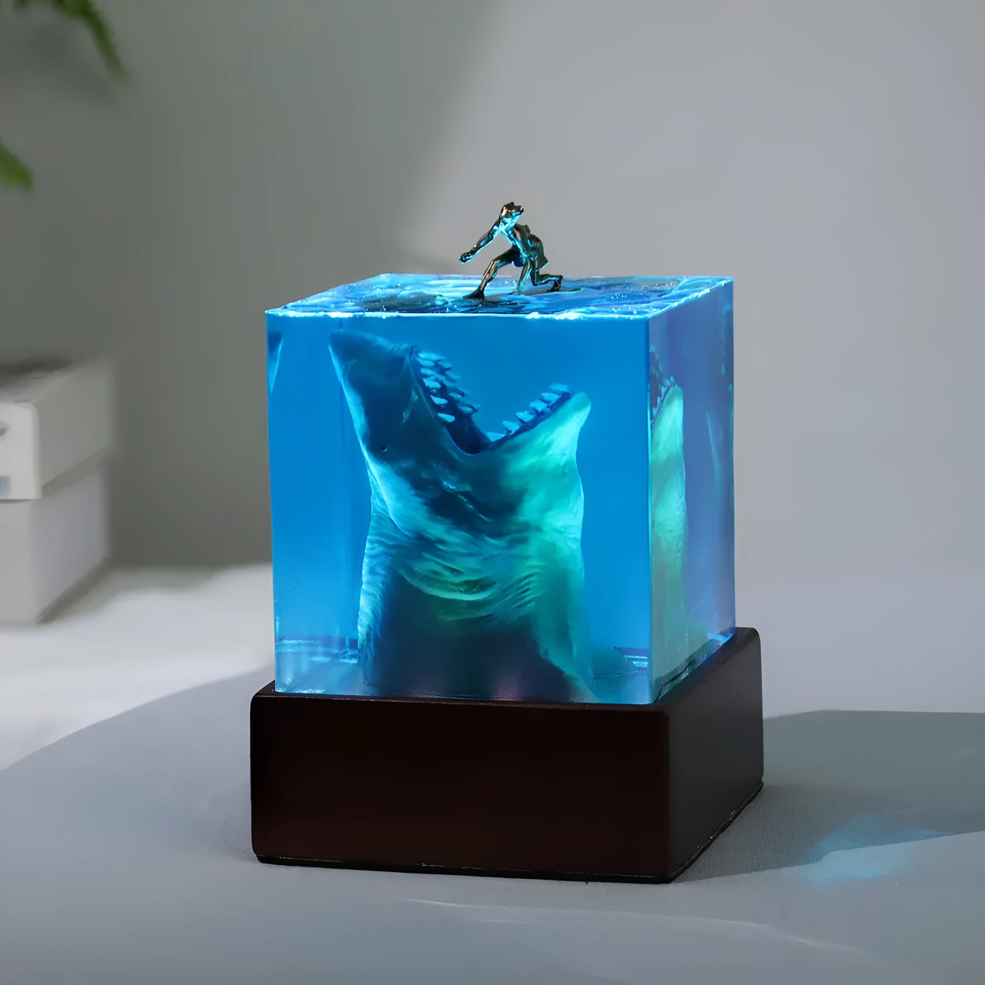 Clear epoxy resin ornament with shark surfer scene inside, next to 5cm and 8cm size options.