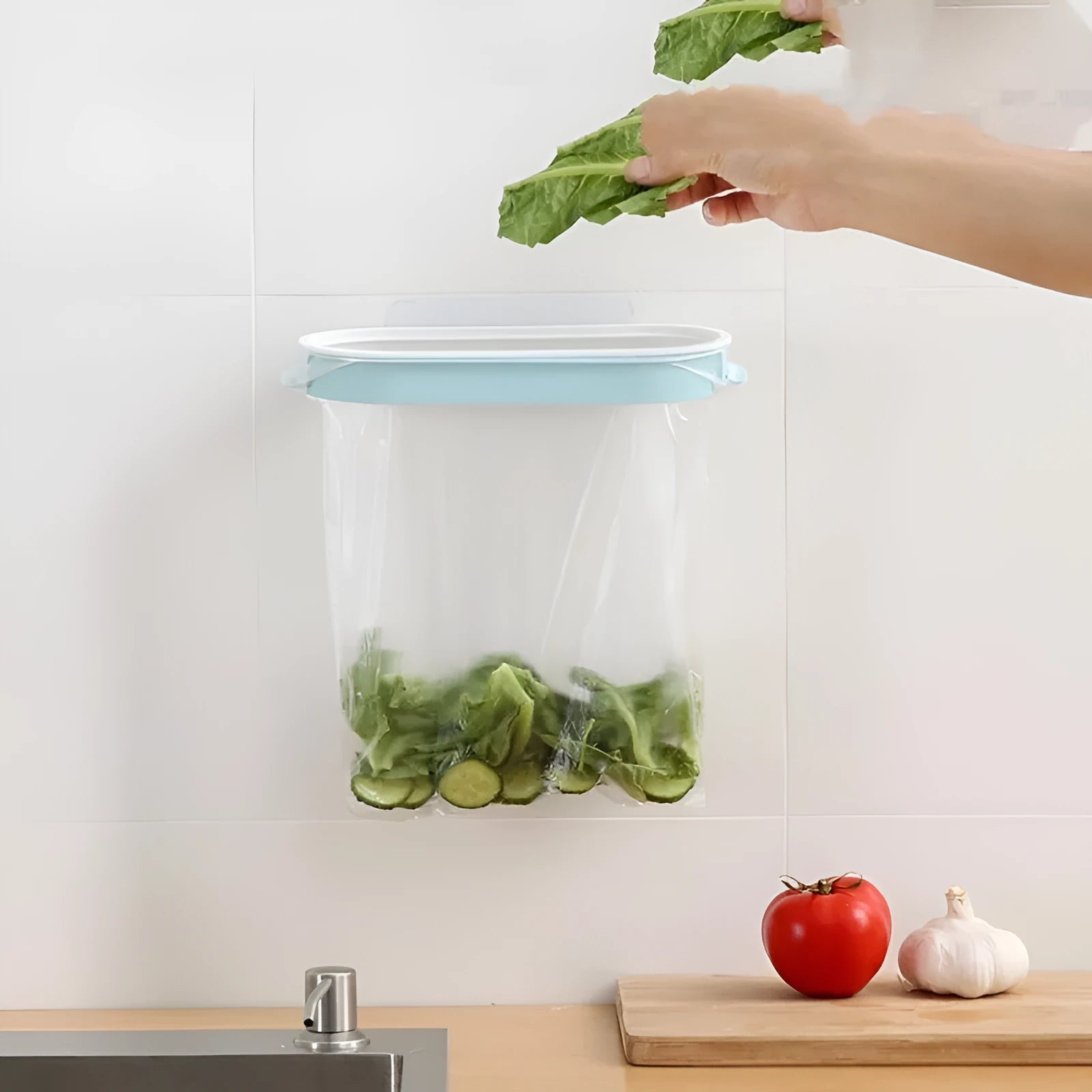 Blue plastic kitchen garbage bag storage rack mounted under cabinet holding roll of bin liners