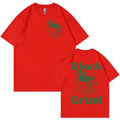 Man wearing a black loose-fit t-shirt with a green 'Rise And Grind' coffee cartoon graphic on the front.