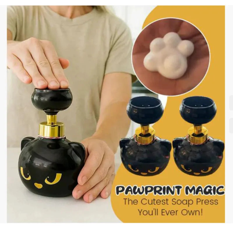 Black cartoon cat shaped manual foam soap dispenser on a counter.