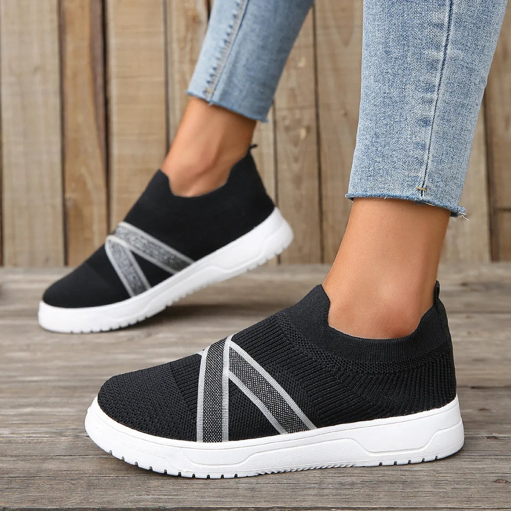 Black women's flat shoes with flyknit mesh fabric upper, rubber sole and tassel detail