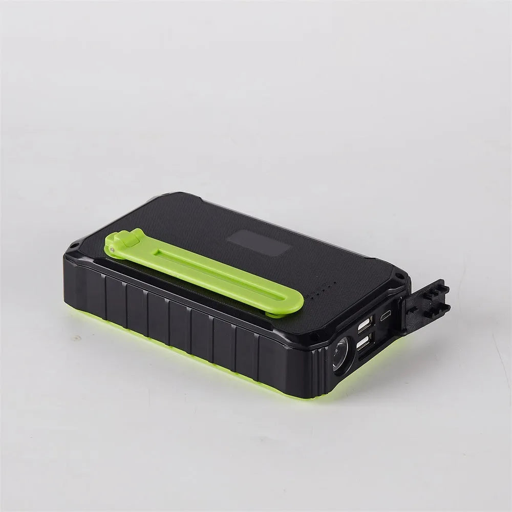 Green or orange hand crank solar power bank with LED light showing USB ports and solar panel.