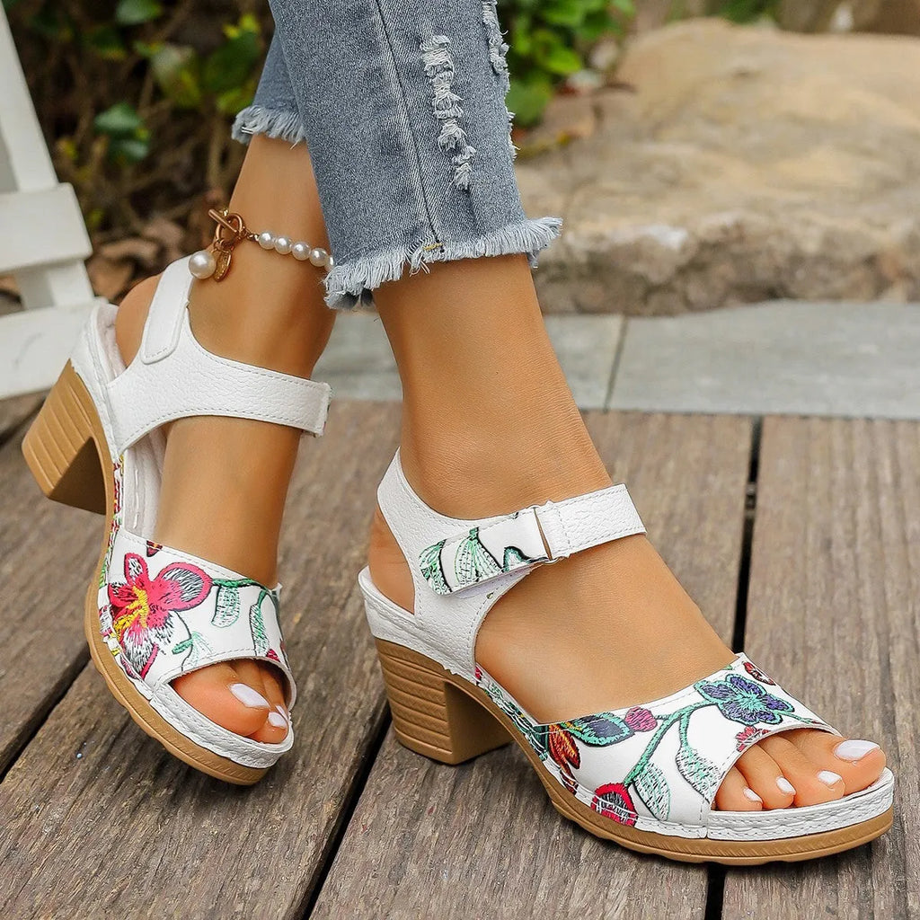 White women's high heel sandals with an adjustable Velcro strap buckle on the ankle.