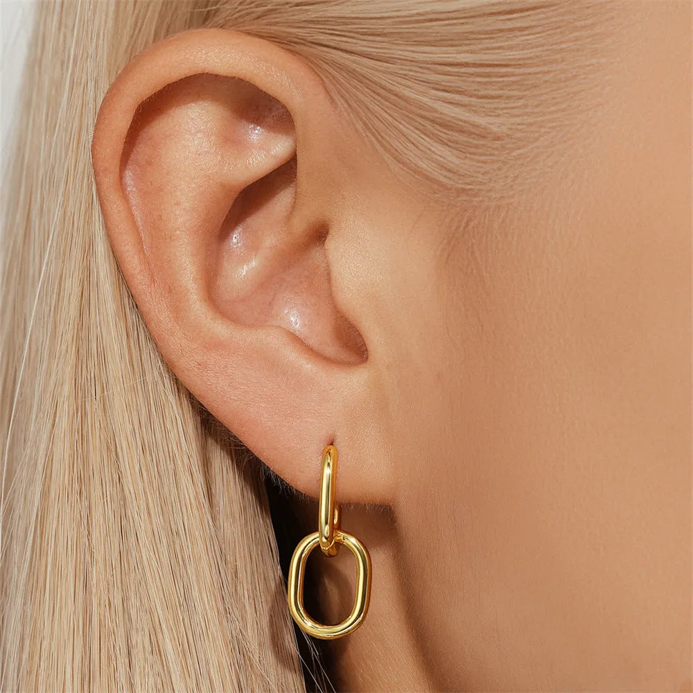 Golden geometric clip-on earrings with round design elements and electroplated finish