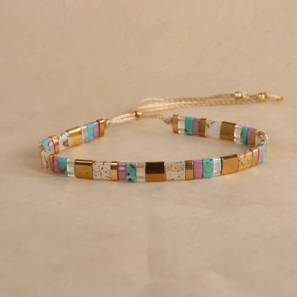 Geometric glass bead pull bracelet in retro green, black, light blue, red, and milky white colours.