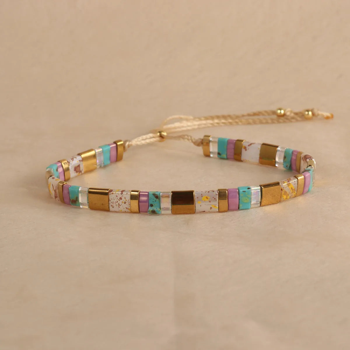 Geometric glass bead pull bracelet in retro green, black, light blue, red, and milky white colours.