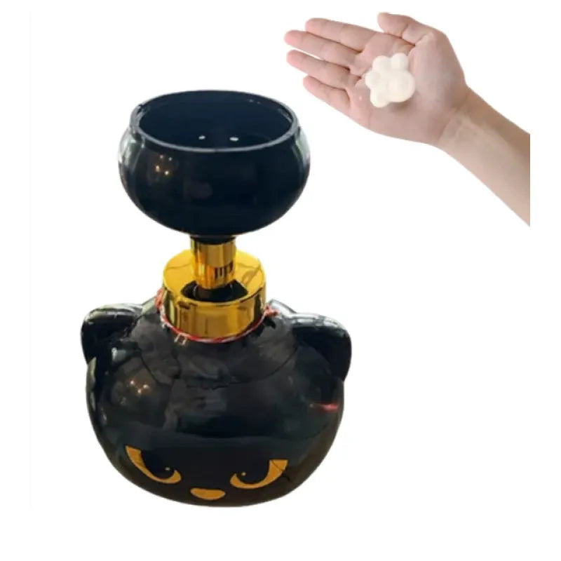 Black cartoon cat shaped manual foam soap dispenser on a counter.