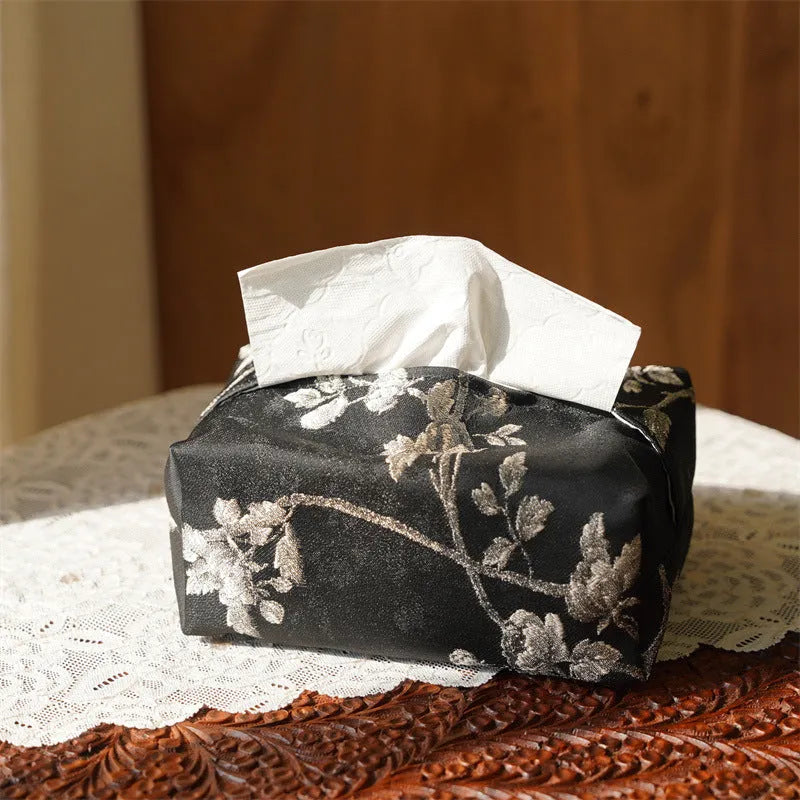 White Chinese brocade tissue box with embroidered plum blossoms, shown with and without a pearl buckle.