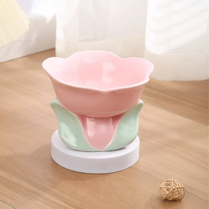 Blue floral patterned ceramic raised pet bowl for cats and dogs on a wooden floor.