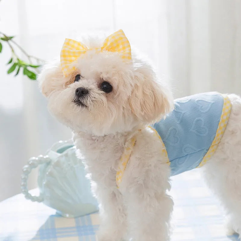 Small dog wearing blue vest with heart texture bow suspenders, elastic construction, casual pet clothing