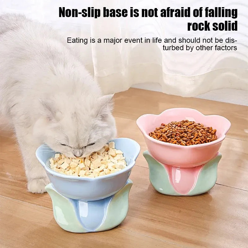 Blue floral patterned ceramic raised pet bowl for cats and dogs on a wooden floor.