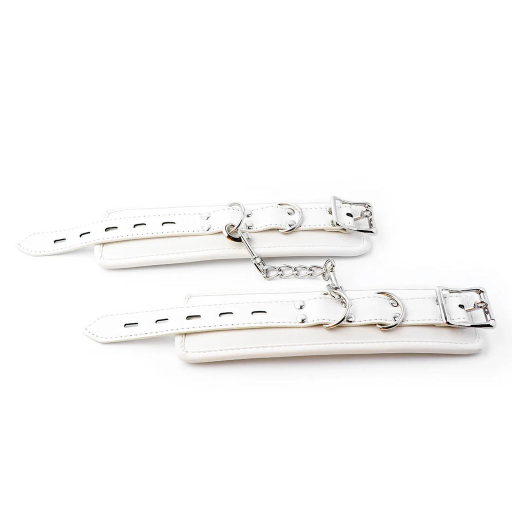 White PU sponge bondage restraint set showing handcuffs, foot cuffs, and a neck cuff.