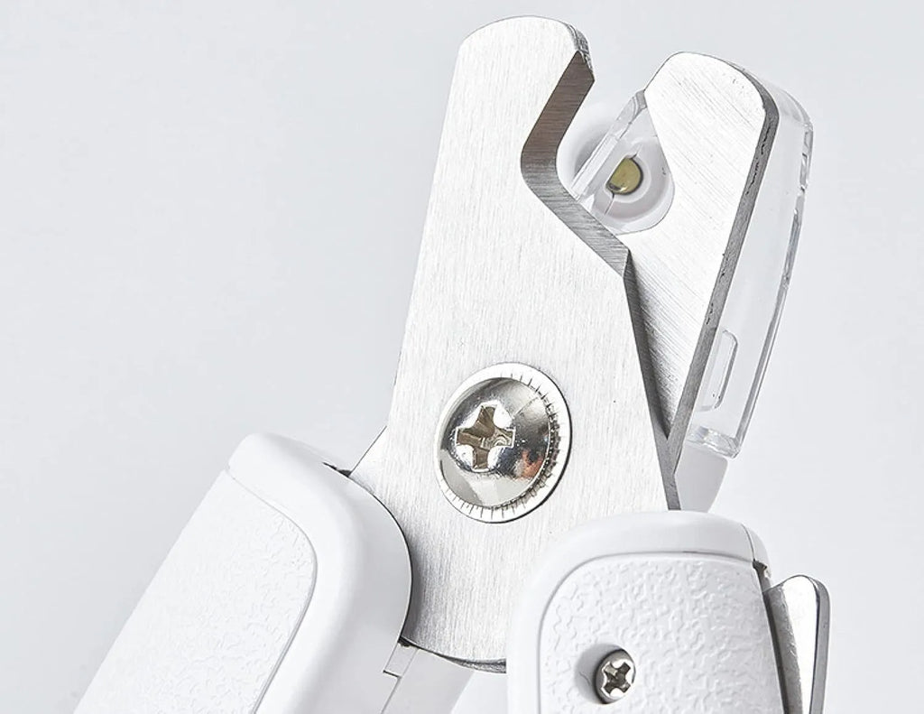 White pet nail clippers with LED light, transparent anti-splash guard open, and separate nail file.