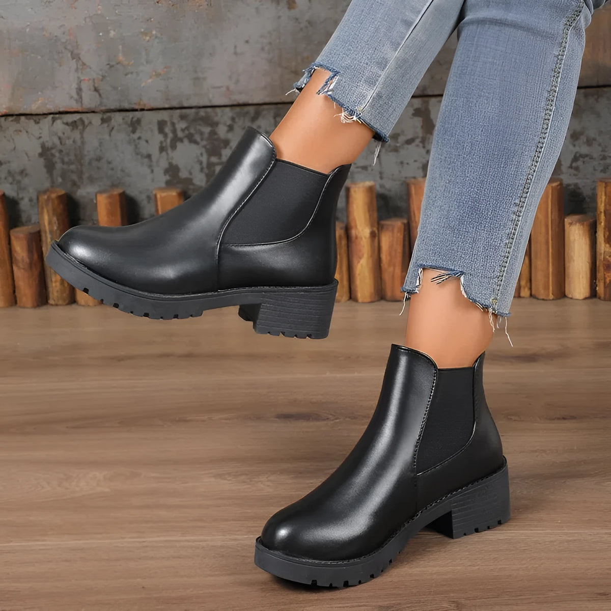Black Chelsea ankle boots for women with flat chunky heel, round toe, and cloth upper on a light background
