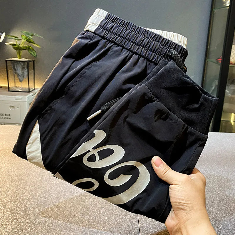 Black men's ultra-thin cotton ankle banded cropped trousers laid flat showing casual design