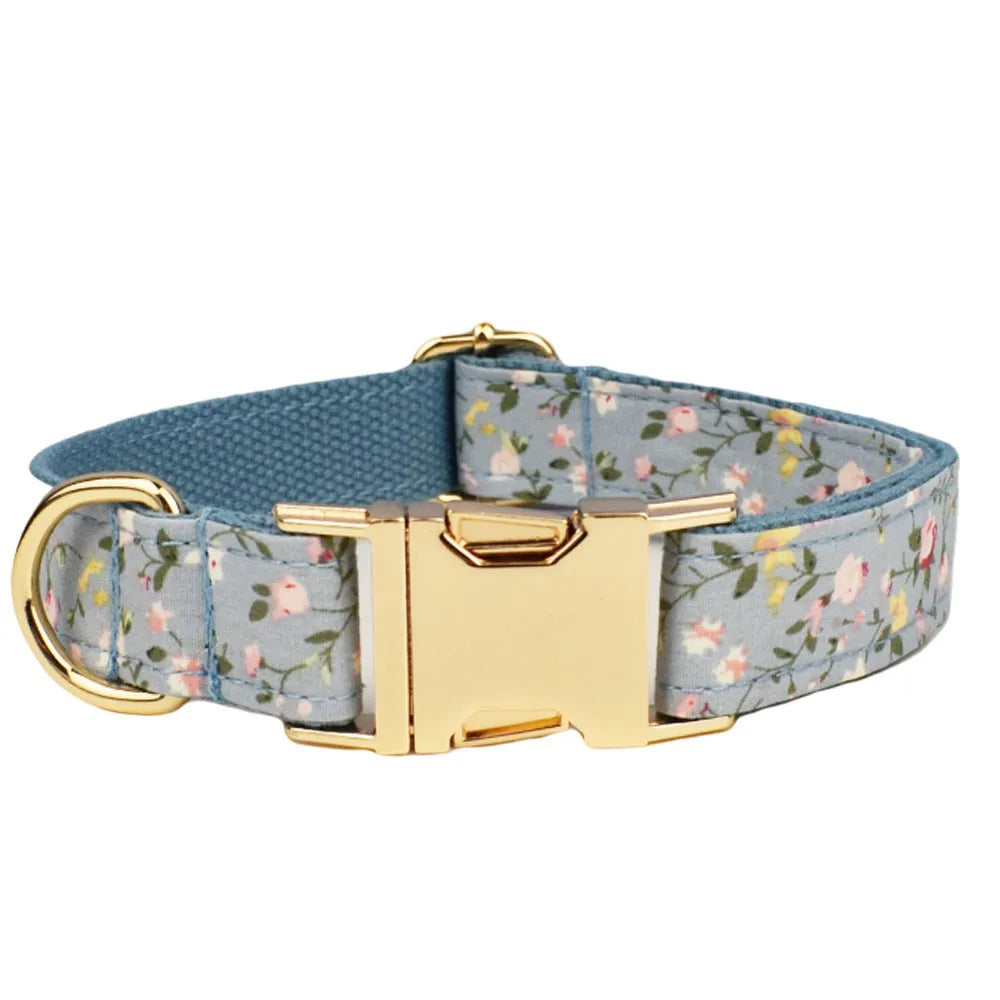 Blue floral pattern dog collar set with matching leash, vest, and accessories on white background
