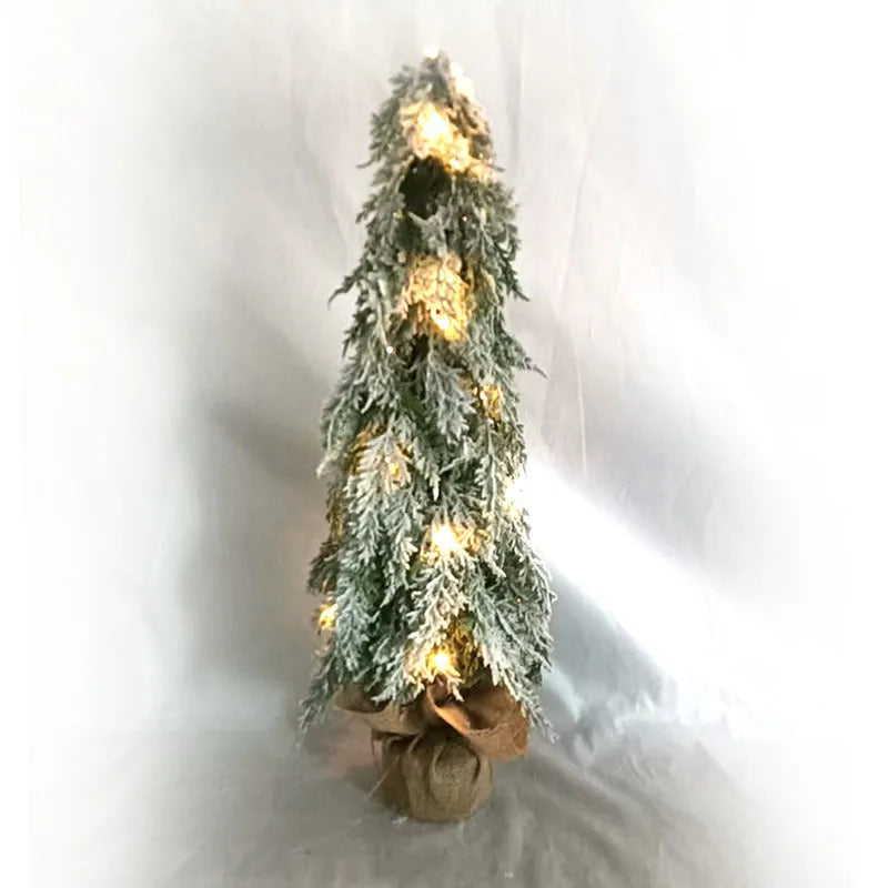 Small 24-inch artificial Christmas tree with white PE snow spray finish, green branches, built-in lights, and a red ornament