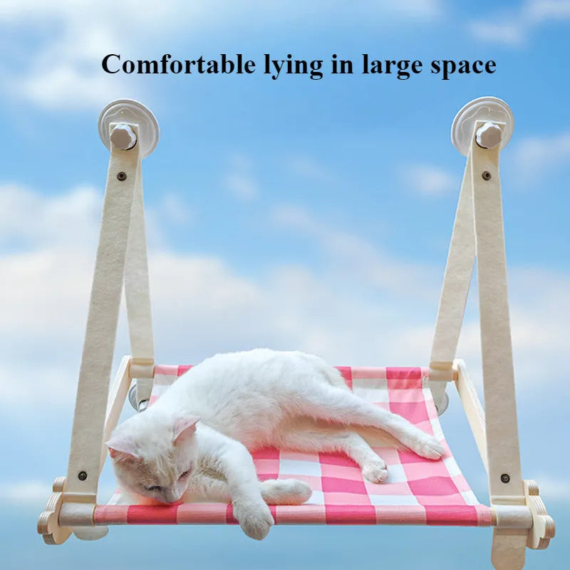 Pink wooden cat hammock bed with suction cups attached to a window
