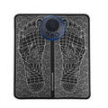 Leather foot massage cushion with wireless remote control and LCD screen on a wooden floor.