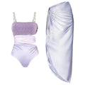 Purple one-piece swimsuit with a matching wrap skirt laid flat on a surface.