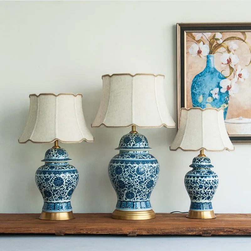 Handmade blue and white porcelain Chinese table lamp with a cloth shade on a wooden surface.