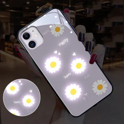 White luminous iPhone case with painted purple daisies and a voice-activated light, shown on a phone.