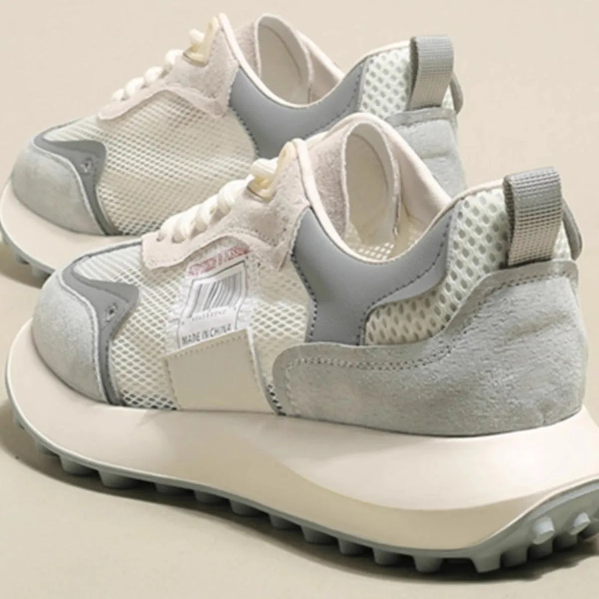 Women's grey and pink low-top retro sneakers with a round toe and flat rubber sole.
