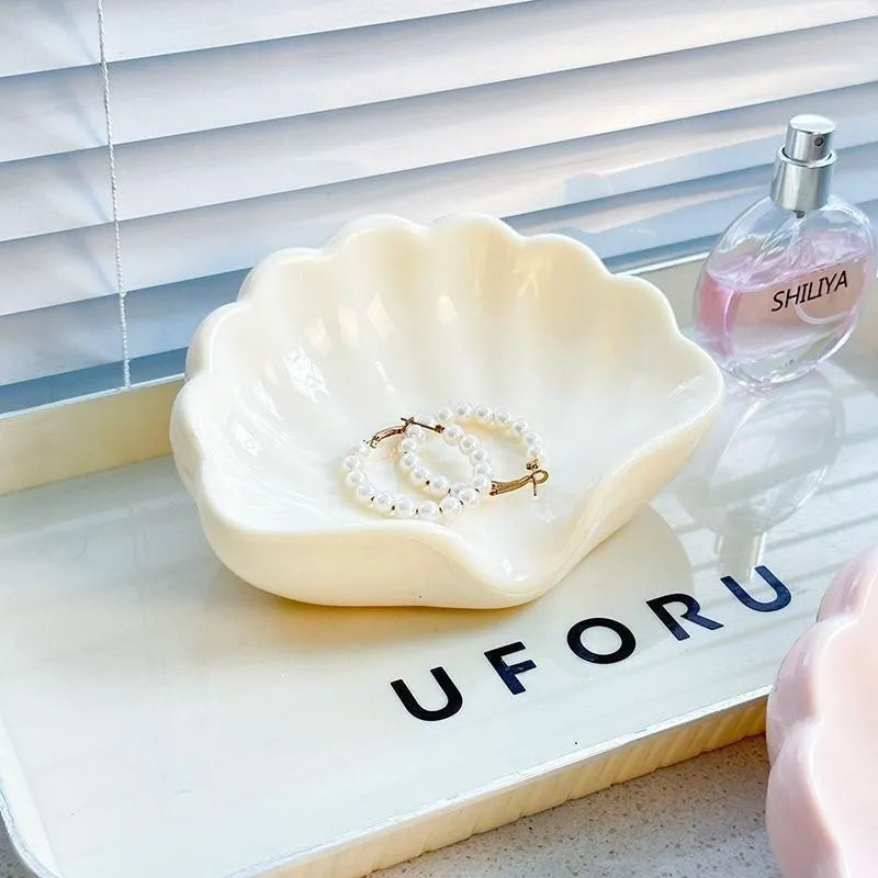 White and pink shell-shaped plastic soap dishes for bathroom countertops.