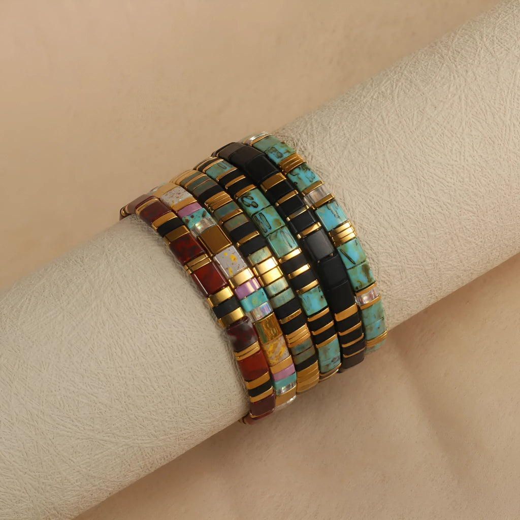 Geometric glass bead pull bracelet in retro green, black, light blue, red, and milky white colours.