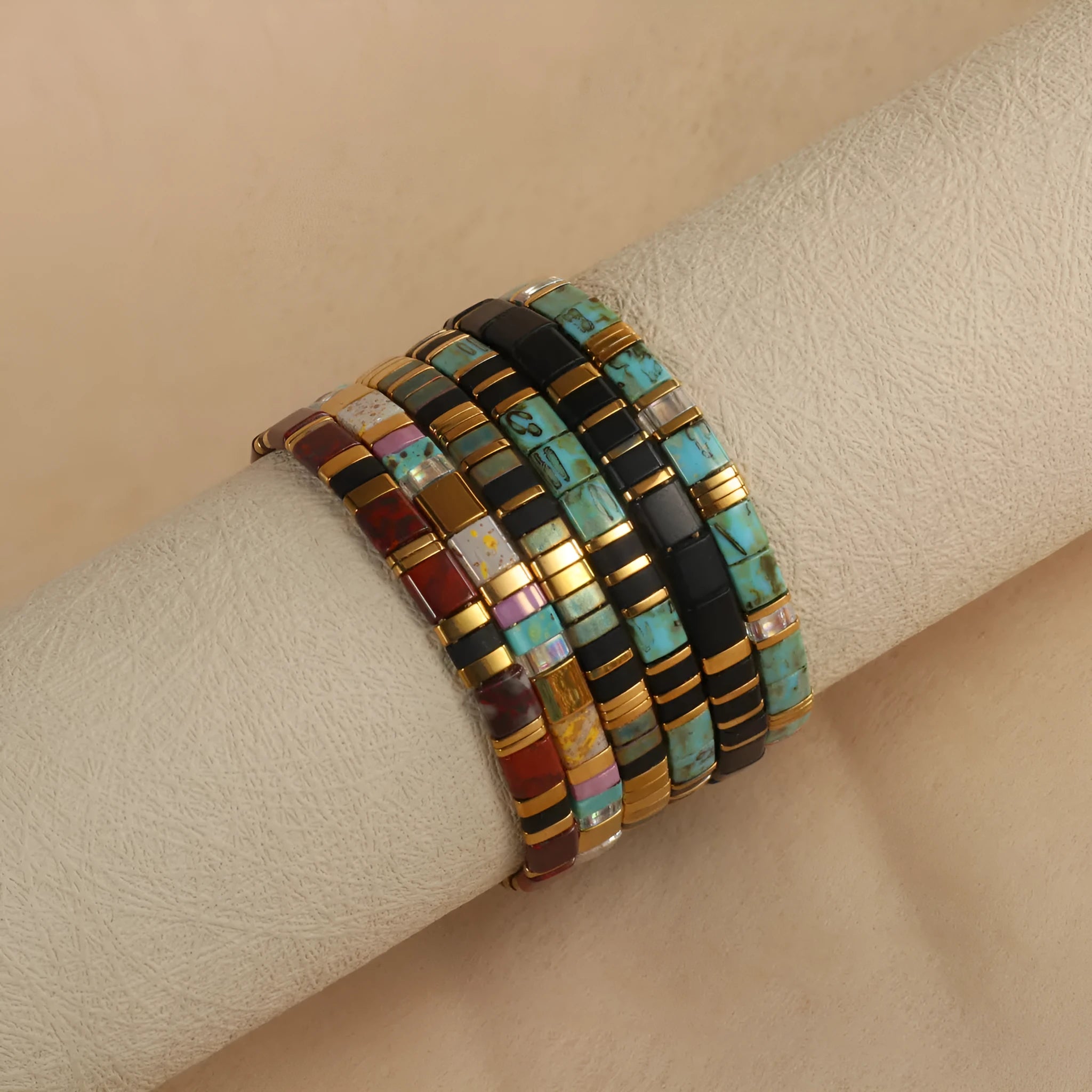 Geometric glass bead pull bracelet in retro green, black, light blue, red, and milky white colours.