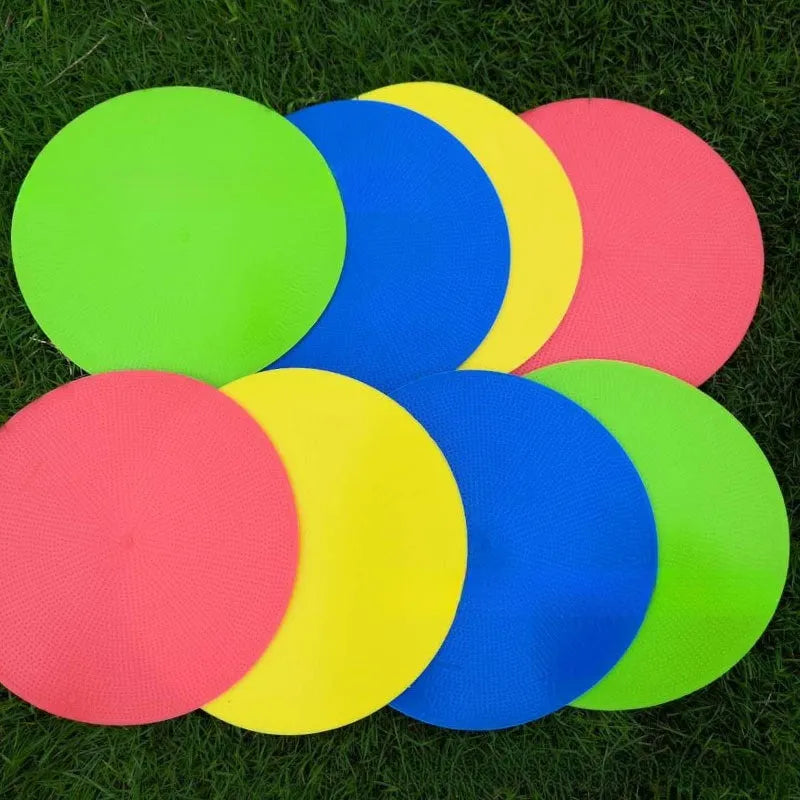 Soft yellow football training target pad, 23cm diameter flat disc on grass.