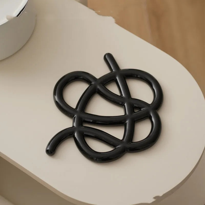 Ceramic heat proof mat with irregular organic shape in solid colour for dining table protection