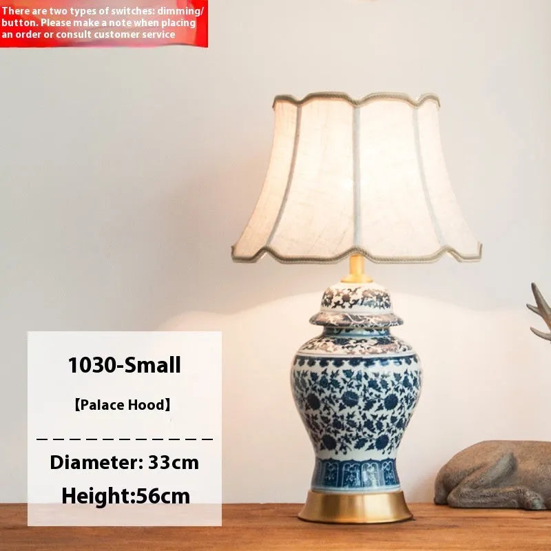 Handmade blue and white porcelain Chinese table lamp with a cloth shade on a wooden surface.