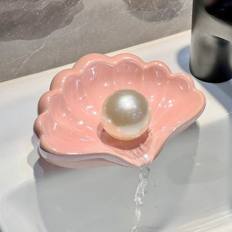 White and pink shell-shaped plastic soap dishes for bathroom countertops.