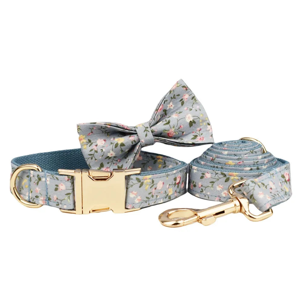 Blue floral pattern dog collar set with matching leash, vest, and accessories on white background