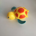 Yellow wind-up plastic turtle water toy on blue surface, 12cm clockwork mechanism